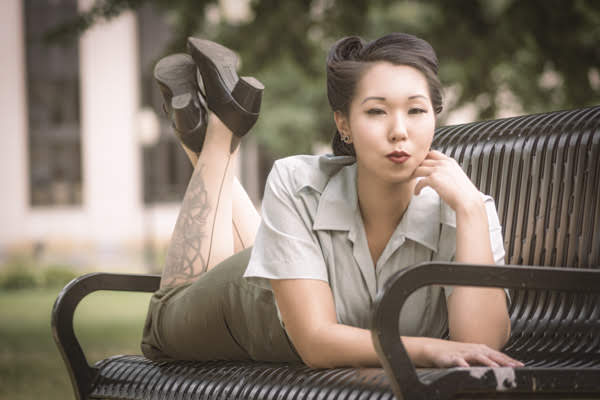 Brenda lying on a park bench in an army uniform.